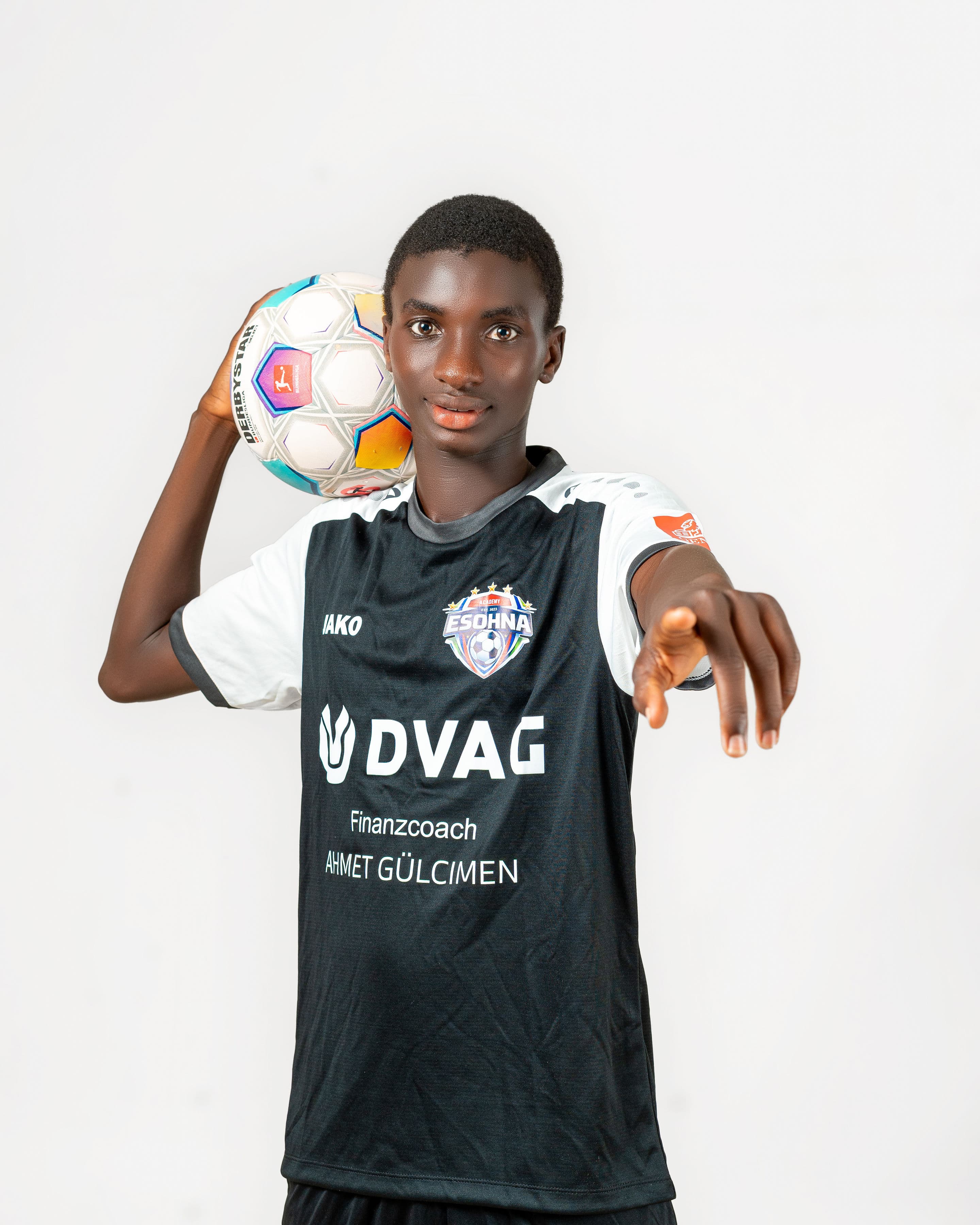 eSohna Academy player holding a football and reaching toward the camera